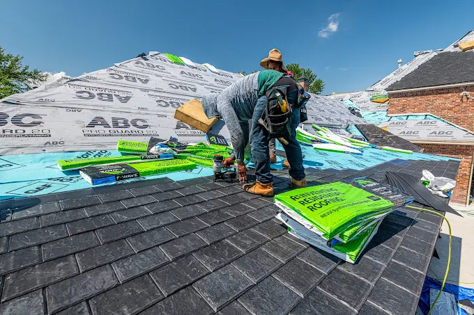 Roofer nailing shingles on a roof during a replacement